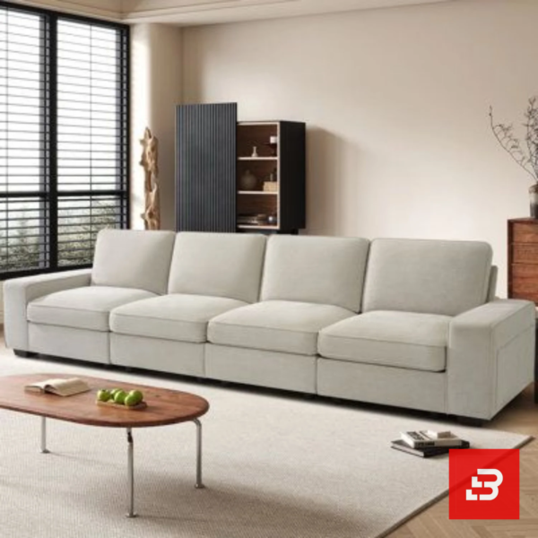 Sunlit interior view of a luxury upholstered linear living room sofa in off white velvet fabric featuring clean modular cushions and a low wooden coffee table by Bahoo Furniture UAE