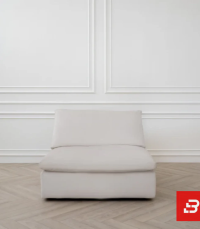 Minimalist studio view of a luxury upholstered modular single armless chair in off white velvet fabric set against a classic white wainscoting wall by Bahoo Furniture UAE