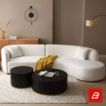 Cozy living room view of a luxury upholstered modern curved sectional sofa in off white bouclé fabric styled with accent pillows, a yellow throw blanket, and black round coffee tables by Bahoo Furniture UAE