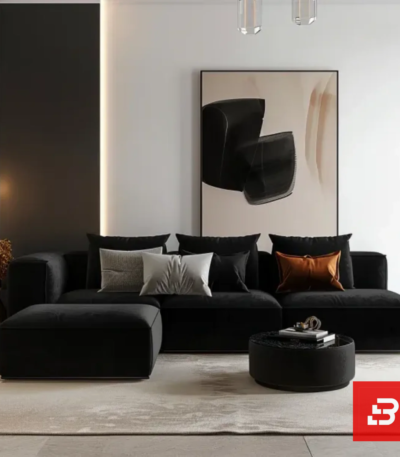 Contemporary interior view of a luxury upholstered modular chaise sectional sofa in warm gray velvet fabric featuring a matching ottoman and accent pillows against a modern wall art backdrop by Bahoo Furniture UAE