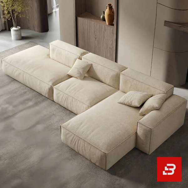 Overhead modern interior view of a luxury upholstered contemporary modular sofa in textured beige fabric featuring an extended chaise lounge and scatter cushions by Bahoo Furniture UAE