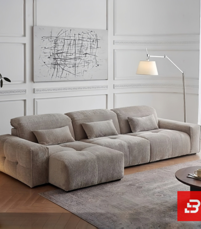 Modern living room interior view of a luxury tufted modular sofa upholstered in textured warm gray bouclé fabric featuring tufted seat cushions and lumbar pillows by Bahoo Furniture UAE