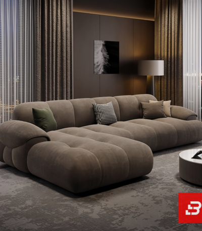 Evening luxury living room interior view of a luxury channel-tufted sectional sofa upholstered in plush warm gray velvet fabric featuring a chaise extension and accent cushions by Bahoo Furniture UAE