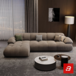 Evening luxury living room interior view of a luxury channel-tufted sectional sofa upholstered in plush warm gray velvet fabric featuring a chaise extension and accent cushions by Bahoo Furniture UAE