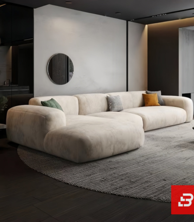 Evening luxury living room interior view of a luxury channel-tufted sectional sofa upholstered in plush warm gray velvet fabric featuring a chaise extension and accent cushions by Bahoo Furniture UAE