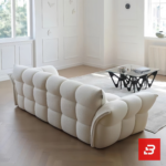 Sunlit minimal modern apartment living room interior view of a luxury channel tufted sofa upholstered in textured off white bouclé fabric featuring structured vertical channel tufting and flared cushioned armrests by Bahoo Furniture UAE