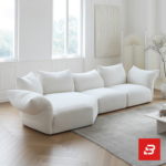 Sunlit minimal modern apartment living room interior view of a luxury cloud sectional upholstered in plush off white bouclé fabric featuring extra-deep lounging cushions and oversized feather-soft scatter pillows by Bahoo Furniture UAE