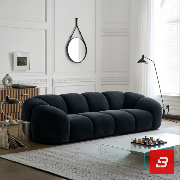 Bright modern minimalist living room interior view of a luxury channel tufted sofa upholstered in textured warm gray bouclé fabric featuring rounded fluted cushions and low-profile armrests by Bahoo Furniture UAE