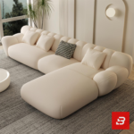 Sunlit minimal modern apartment living room interior view of a luxury fluted sectional upholstered in textured off white bouclé fabric featuring sweeping vertical channel backrests and an extended chaise lounge by Bahoo Furniture UAE