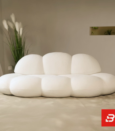 Minimalist modern interior view of a luxury cloud bubble sofa upholstered in textured off white bouclé fabric featuring rounded organic modular lobes and a low-profile silhouette by Bahoo Furniture UAE