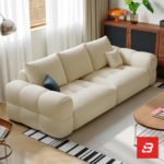 Bright modern living room interior view of a luxury tufted sofa upholstered in textured off white bouclé fabric featuring plush channel-tufted seating cushions and clean modern lines by Bahoo Furniture UAE
