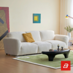 Bright minimalist modern living room interior view of a luxury contemporary modular sofa upholstered in textured off white bouclé fabric featuring clean streamlined armrests and low-profile cushions by Bahoo Furniture UAE