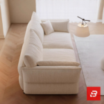 Bright minimalist modern living room interior view of a luxury low-slung sofa upholstered in textured off white bouclé fabric featuring extra deep plush cushions and relaxed angled armrests by Bahoo Furniture UAE