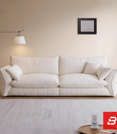 Bright minimalist modern living room interior view of a luxury low-slung sofa upholstered in textured off white bouclé fabric featuring extra deep plush cushions and relaxed angled armrests by Bahoo Furniture UAE