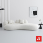 Bright minimalist modern living room interior showcasing an asymmetric chaise sofa upholstered in textured off white bouclé fabric featuring fluid organic curves and matching scatter cushions by Bahoo Furniture UAE