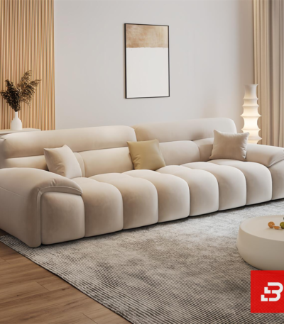 Bright elegant modern living room interior showcasing a luxury modular channel sofa upholstered in textured beige bouclé fabric featuring vertical channel tufting and stylish accent pillows by Bahoo Furniture UAE