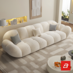 Bright warm modern living room interior showcasing a luxury cloud sectional sofa upholstered in textured off white bouclé fabric featuring pillowy channel modules and chic houndstooth accent pillows by Bahoo Furniture UAE