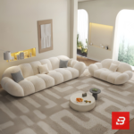 Bright warm modern living room interior showcasing a luxury cloud sectional sofa upholstered in textured off white bouclé fabric featuring pillowy channel modules and chic houndstooth accent pillows by Bahoo Furniture UAE