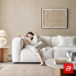 Bright modern living room interior showcasing a luxury modular sectional sofa upholstered in textured off white bouclé fabric featuring a comfortable chaise lounge and neutral decorative pillows by Bahoo Furniture UAE