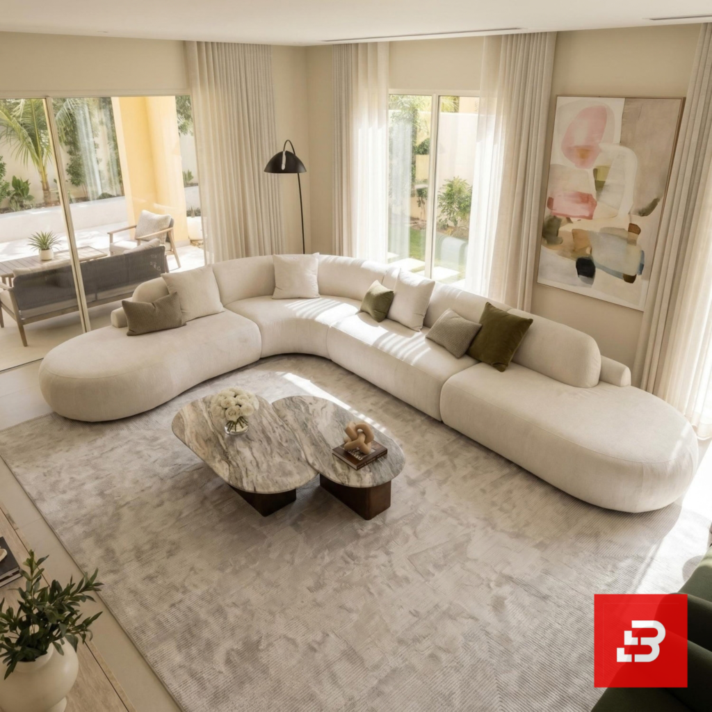 Sunlit luxury living room interior view of a luxury grand curved sectional sofa upholstered in textured beige bouclé fabric featuring extended chaise ends and scatter cushions by Bahoo Furniture UAE