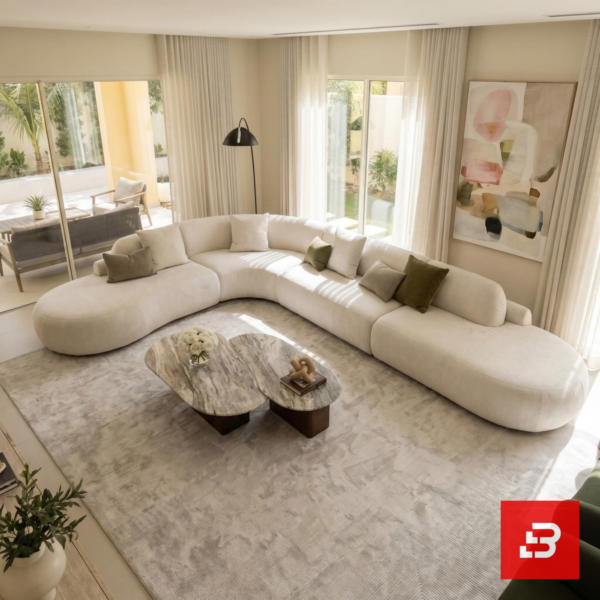 Sunlit luxury living room interior view of a luxury grand curved sectional sofa upholstered in textured beige bouclé fabric featuring extended chaise ends and scatter cushions by Bahoo Furniture UAE