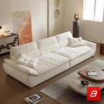 Sunlit luxury living room interior view of a luxury plush cushion sofa upholstered in soft off white fabric featuring deep channeled cushions and matching throw pillows by Bahoo Furniture UAE
