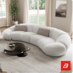 Bright modern living room interior view of a luxury flowing curved sofa upholstered in textured off white bouclé fabric featuring sweeping modular contours and ribbed scatter cushions by Bahoo Furniture UAE