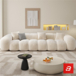Bright warm living room interior view of a luxury ribbed modular sofa upholstered in textured off white bouclé fabric featuring distinct vertical channeled rolls and accent cushions by Bahoo Furniture UAE