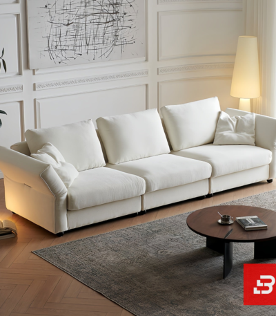 Warm elegant living room interior view of a luxury plump cushion sofa upholstered in textured off white bouclé fabric featuring deep plush back pillows and angled armrests by Bahoo Furniture UAE