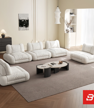 Bright elegant apartment living room interior view of a luxury independent modular lounge sofa upholstered in textured off white bouclé fabric featuring separate modular armchair elements by Bahoo Furniture UAE