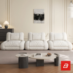 Bright elegant apartment living room interior view of a luxury independent modular lounge sofa upholstered in textured off white bouclé fabric featuring separate modular armchair elements by Bahoo Furniture UAE