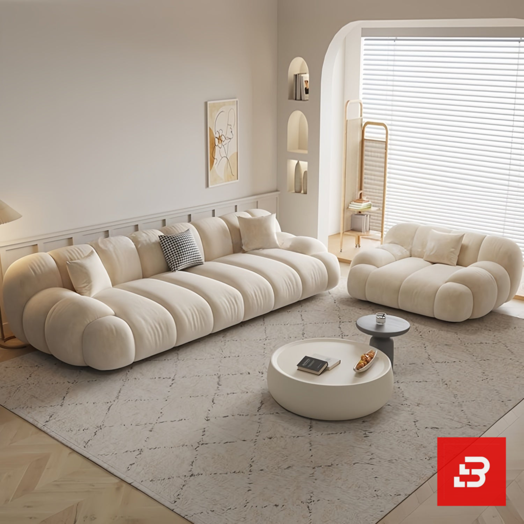 Bright modern sunlit living room interior view of a luxury channel modular lounge set upholstered in textured off white bouclé fabric featuring horizontal ribbed modules, an armchair, and an ottoman by Bahoo Furniture UAE
