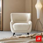 Warm minimalist living room interior showcasing a luxury wingback armchair upholstered in soft off white bouclé fabric featuring supportive flared wings and dark wooden legs by Bahoo Furniture UAE