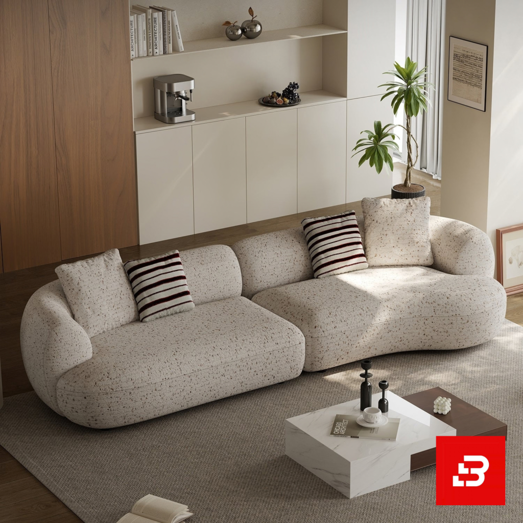 Elegant modern minimalist living room interior showcasing an asymmetric curved sofa upholstered in textured beige bouclé fabric featuring speckled details and stylish striped accent pillows by Bahoo Furniture UAE