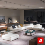 Sophisticated modern luxury showroom living room interior showcasing an expansive modular sectional sofa upholstered in textured off white bouclé fabric featuring deep tufted seats, built-in side tables, and chic decorative pillows by Bahoo Furniture UAE