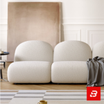 Elegant modern minimalist living room interior showcasing a modular bubble sofa upholstered in textured off white bouclé fabric featuring rounded organic backrests and a dark throw blanket by Bahoo Furniture UAE