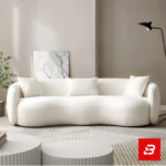 Sunlit modern minimalist living room interior showcasing a luxury curved sofa upholstered in textured off white bouclé fabric featuring sweeping rounded armrests and matching throw pillows by Bahoo Furniture UAE