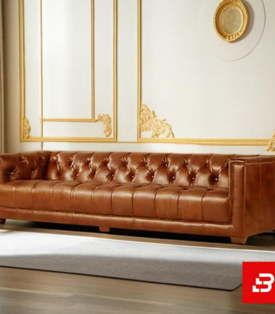 Classic elegant living room interior showcasing a luxury chesterfield sofa upholstered in rich beige leather fabric featuring deep button tufting and rolled arms by Bahoo Furniture UAE