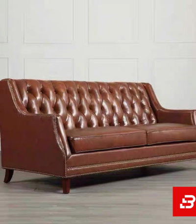 Classic elegant living room interior showcasing a luxury wingback tufted sofa upholstered in rich beige leather fabric featuring deep button tufting and nailhead trim by Bahoo Furniture UAE