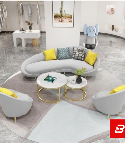 Modern upscale living room interior showcasing a luxury curved sofa upholstered in warm gray bouclé fabric featuring organic sweeping lines and matching round club armchairs by Bahoo Furniture UAE
