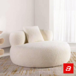 Bright modern room interior showcasing a luxury round accent chair upholstered in soft off white bouclé fabric featuring cylindrical armrests and a matching throw pillow by Bahoo Furniture UAE