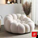 Cozy modern room interior showcasing a luxury bubble armchair upholstered in soft off white bouclé fabric featuring tufted channel cushioning and rounded contours by Bahoo Furniture UAE
