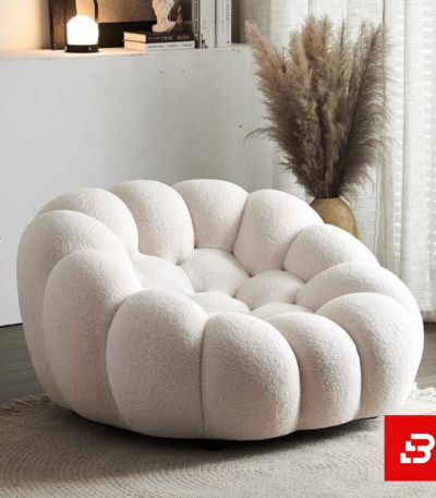 Cozy modern room interior showcasing a luxury bubble armchair upholstered in soft off white bouclé fabric featuring tufted channel cushioning and rounded contours by Bahoo Furniture UAE