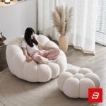 Cozy modern room interior showcasing a luxury bubble armchair upholstered in soft off white bouclé fabric featuring tufted channel cushioning and rounded contours by Bahoo Furniture UAE