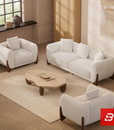 Stylized living room interior view of a luxury upholstered contemporary sofa set featuring a 3-seater sofa and two matching armchairs in off white bouclé fabric with dark wooden base accents by Bahoo Furniture UAE