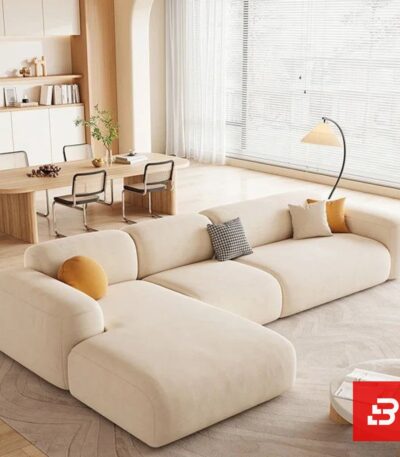 Modern living room interior view of a luxury upholstered contemporary sectional sofa with a plush chaise lounge and accent pillows in off white bouclé fabric by Bahoo Furniture UAE