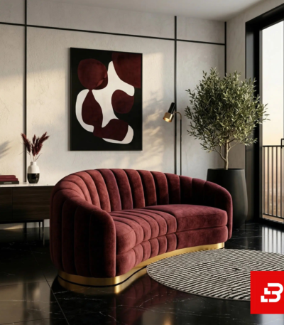 Sophisticated modern living room interior showcasing a luxury channel-tufted sofa upholstered in soft beige velvet fabric featuring a rounded curved back and a gold metallic base plinth by Bahoo Furniture UAE