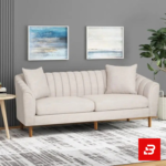 Sophisticated modern living room interior showcasing a luxury channel-tufted sofa upholstered in soft off white textured fabric featuring vertical back channeling and wooden tapered legs by Bahoo Furniture UAE