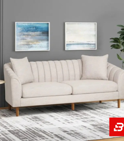 Sophisticated modern living room interior showcasing a luxury channel-tufted sofa upholstered in soft off white textured fabric featuring vertical back channeling and wooden tapered legs by Bahoo Furniture UAE