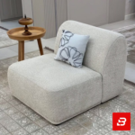 Modern elegant living space featuring a low-profile off white bouclé modular armless lounge chair styled with an embroidered cushion and wooden side table by Bahoo Furniture UAE
